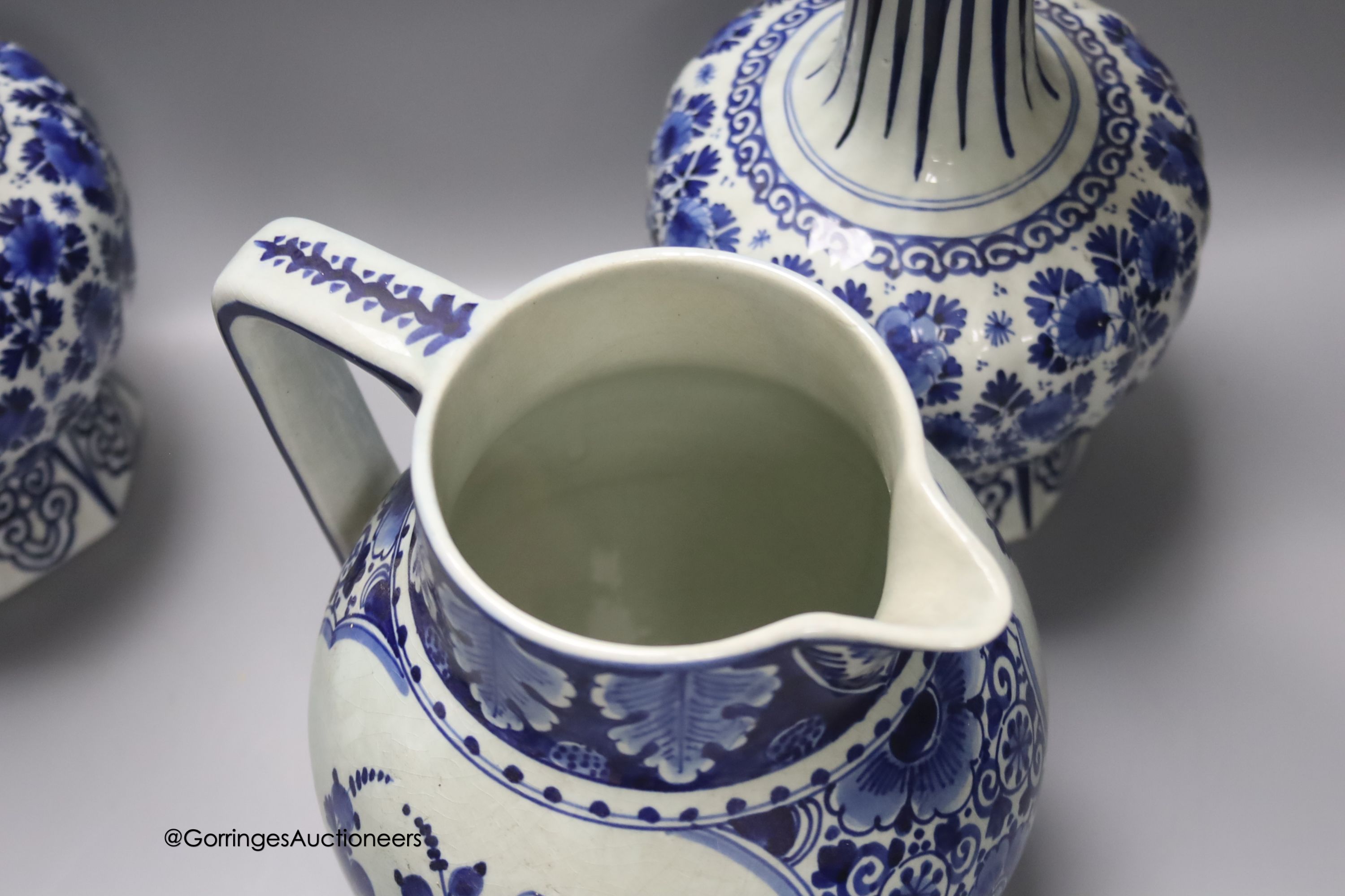 A pair of Dutch Delft blue and white vases, 29cm, a similar ovoid jar and cover and a bulbous jug